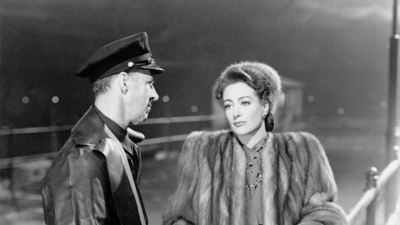 a man with a hat talkng to Joan Crawford